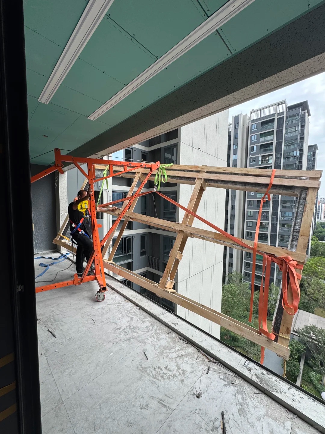 安装人员在公寓阳台现场搬运和安装大型窗框