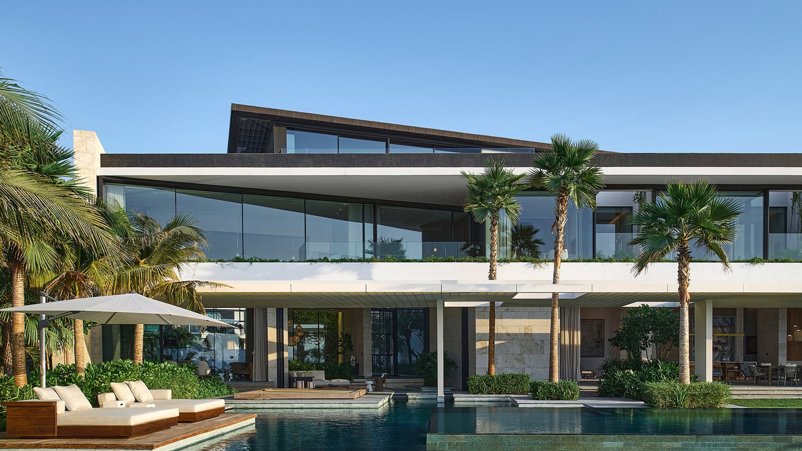 Poolside villa exterior with a glazed facade and terrace